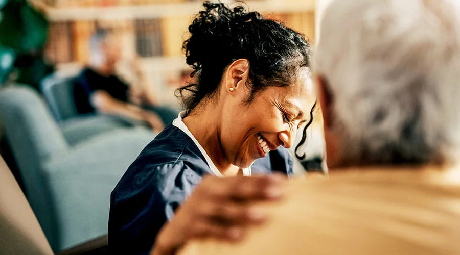 Trabajador de la salud sonriendo durante una consulta Trabajador de la salud sonriendo durante una consulta