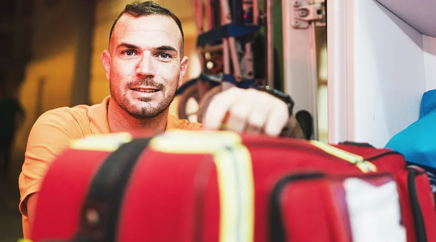 Repartidor sosteniendo una bolsa médica roja en interiores