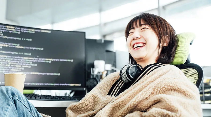 Femme souriant tout en travaillant à l'ordinateur au bureau Femme souriant tout en travaillant à l'ordinateur au bureau