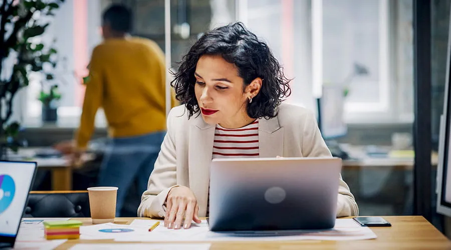 Person working on laptop at desk Person working on laptop at desk