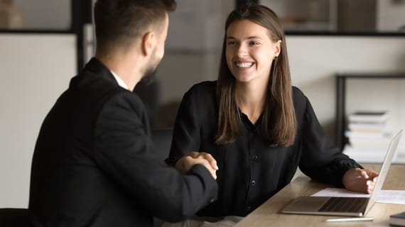 Lors d’un entretien d’embauche, une femme et un homme se serrent la main car ils ont conclu positivement l’entretien Lors d’un entretien d’embauche, une femme et un homme se serrent la main car ils ont conclu positivement l’entretien