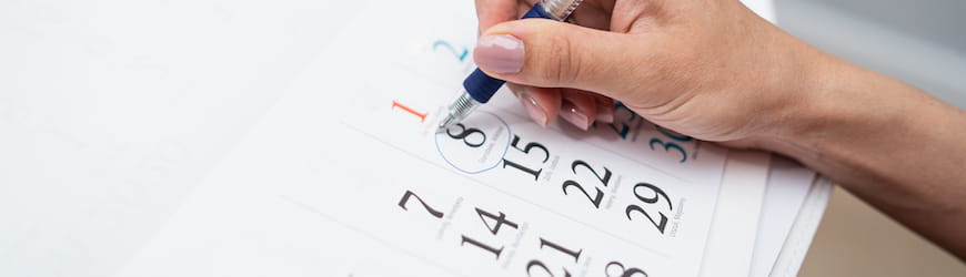 une jeune femme qui coche les cases d’un calendrier