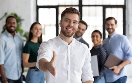 homme face caméra serre la main
