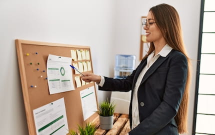 Une intérimaire consulte le panneau d'affichage obligatoire de son entreprise utilisatrice. 