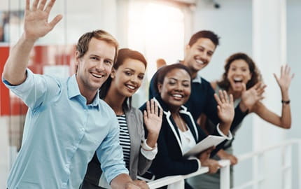 Une équipe de salariés font un signe de la main pour accueillir un nouvel employé. Une équipe de salariés font un signe de la main pour accueillir un nouvel employé.