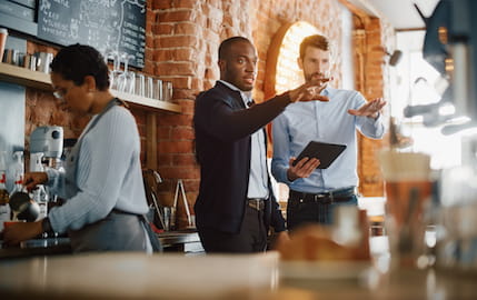 Un gérant de TPE de la restauration discute avec son salarié récemment recruté.