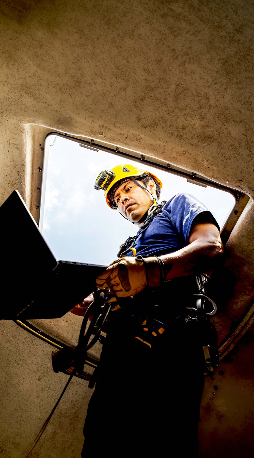 Técnico trabajando con equipo en un espacio confinado