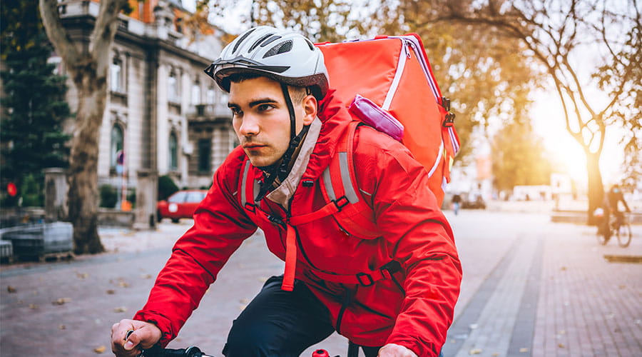 Repartidor montado en una bicicleta concretado en llegar a su destino Repartidor montado en una bicicleta concretado en llegar a su destino