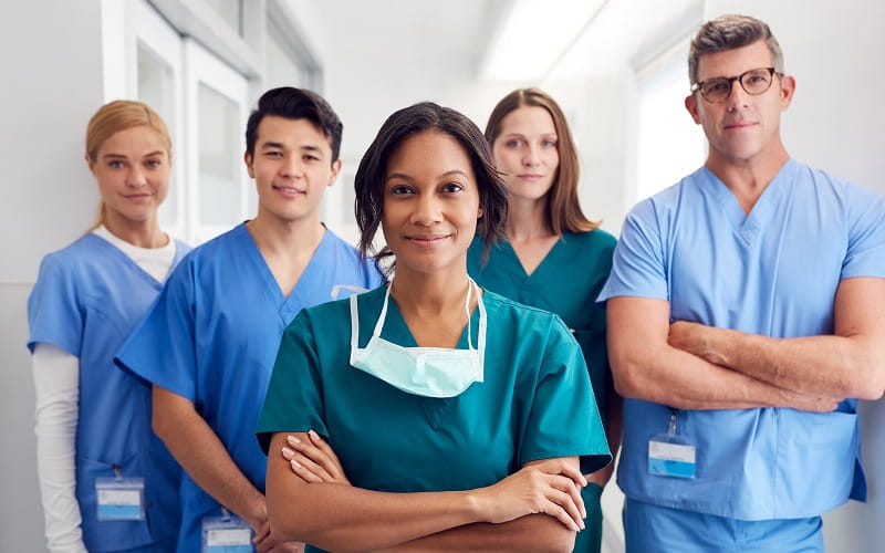 Portrait D'Une Équipe Médicale Multiculturelle Se Tenant Dans Le Corridor De L'Hôpital