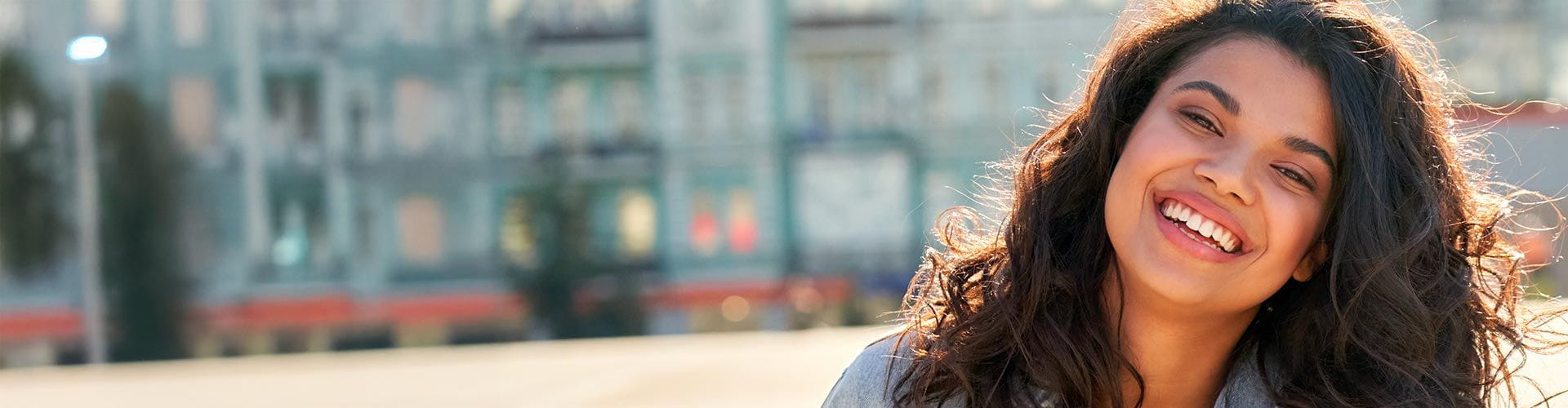  Une femme avec un grand sourire avec en arrière-plan une ville