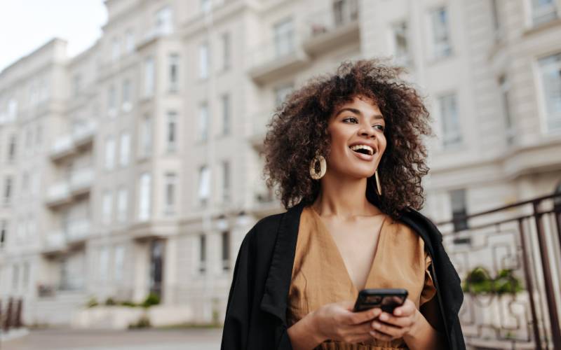 Une-jeune-femme-marche-dans-la-rue-avec-son-téléphone