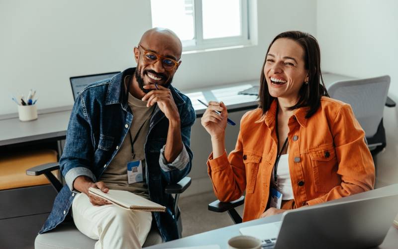 Un-homme-et-une-femme-souriant-à-leur-bureau