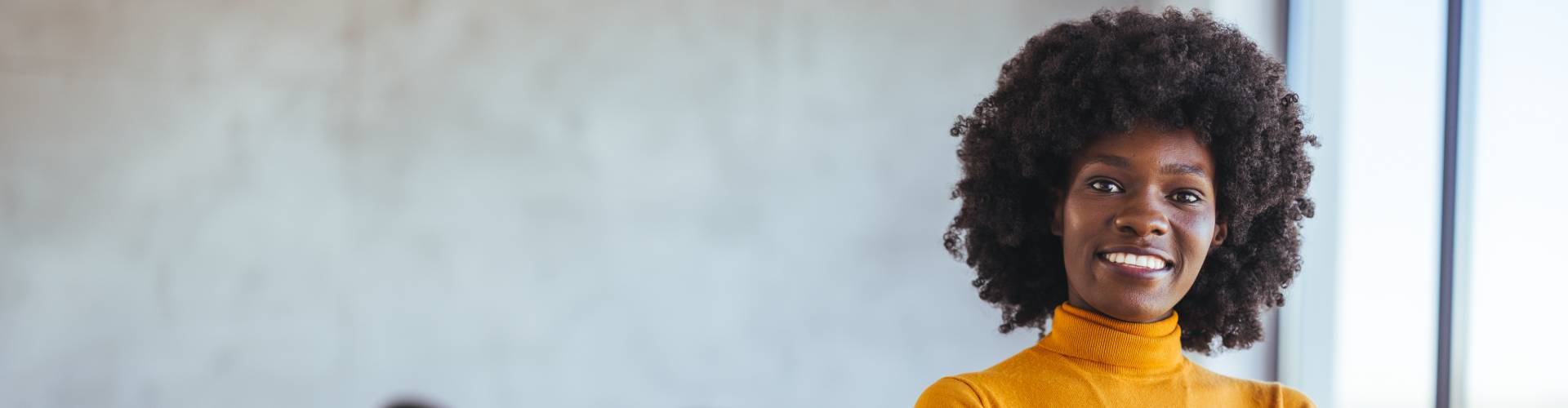 Une femme noire sourit face à la caméra