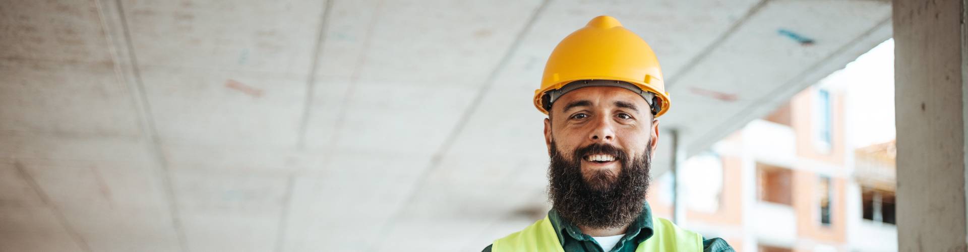 Homme barbu avec un casque  travaillant dans le secteur du BTP