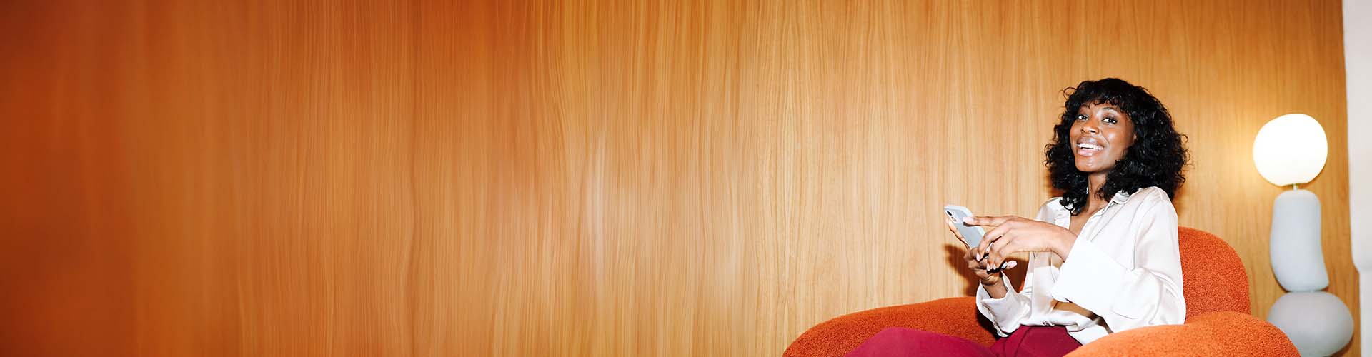 Une femme souriante utilisant la solution QAPA sur son smartphone