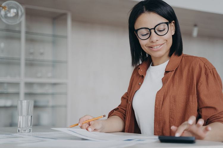 Une femme au travail calculant le coût d’un contrat en CDD​