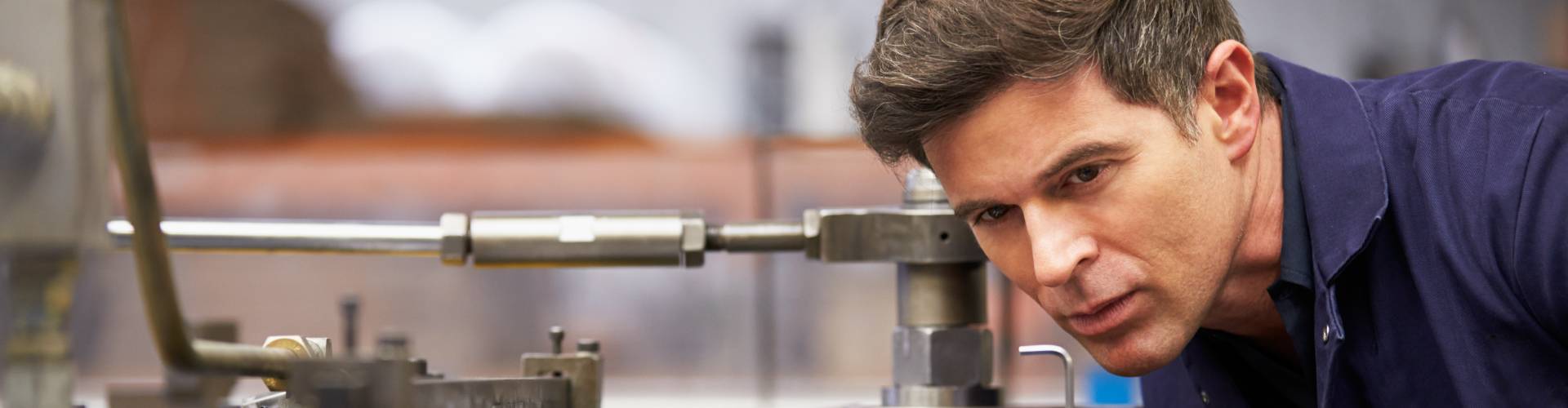 Homme travaillant sur une machine hydraulique