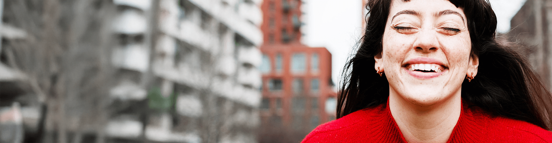 Personne souriant à l'extérieur dans une rue de la ville