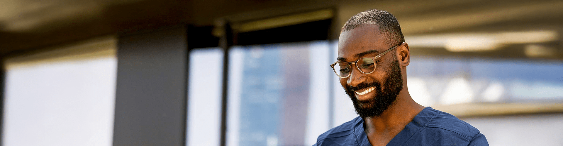 Professionnel de la santé souriant en tenue de bloc dans un cadre clinique