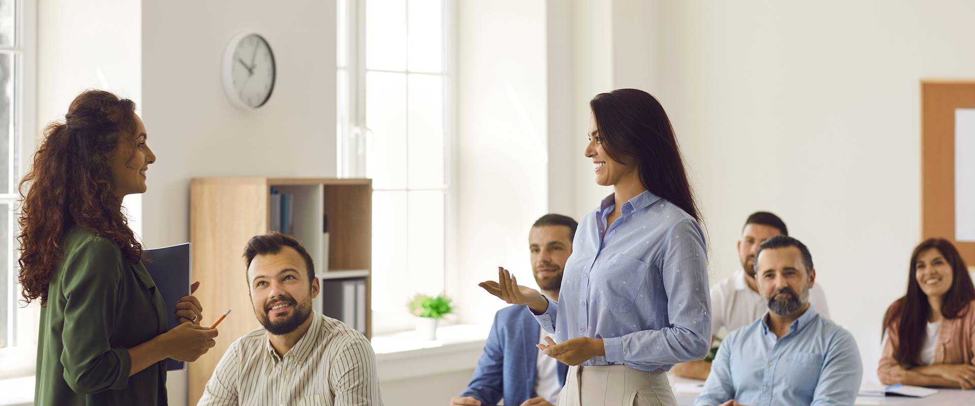 Groupe d'étudiants adultes discutant avec un entraîneur d'affaires lors de cours de formation