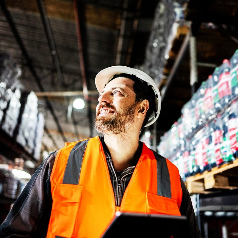 Un homme souriant travaillant sur un site logistique 