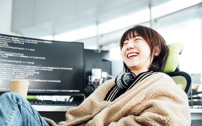 une salariée souriante travaillant dans le domaine technologique