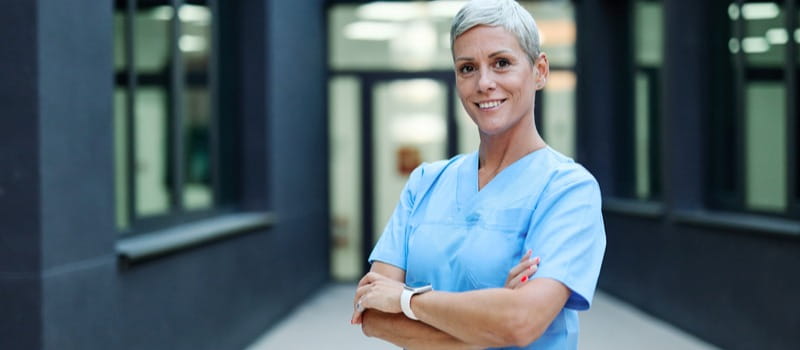 Une soignante souriante cumulant emploi et retraite 