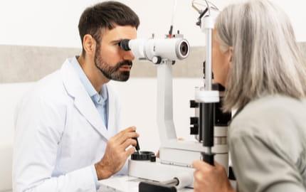 Ophtalmologue réalisant une consultation visuelle avec une patiente dans un cabinet d’ophtalmologie