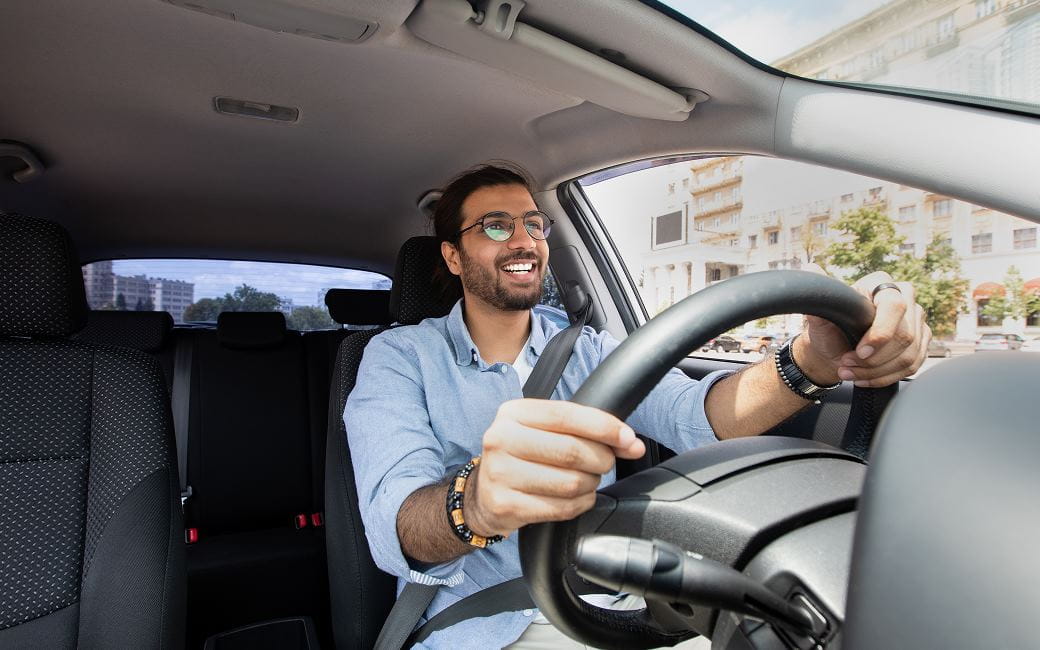 Un homme joyeux conduisant une voiture pour aller au travail