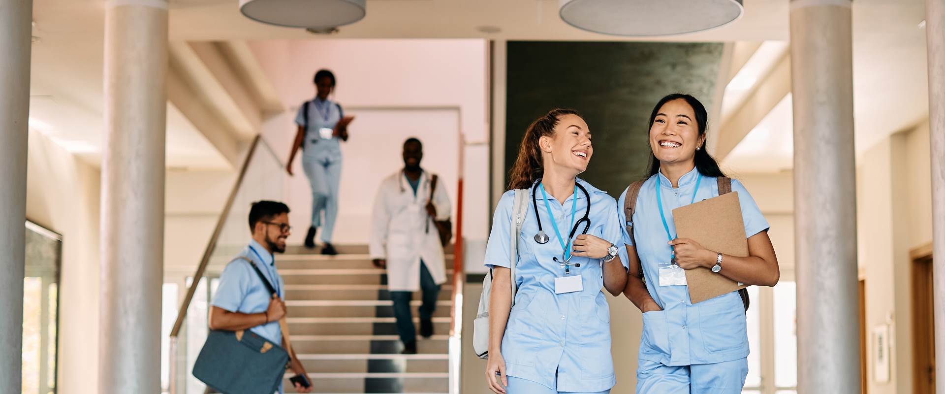 Deux assistantes médicales heureuses marchent dans un couloir