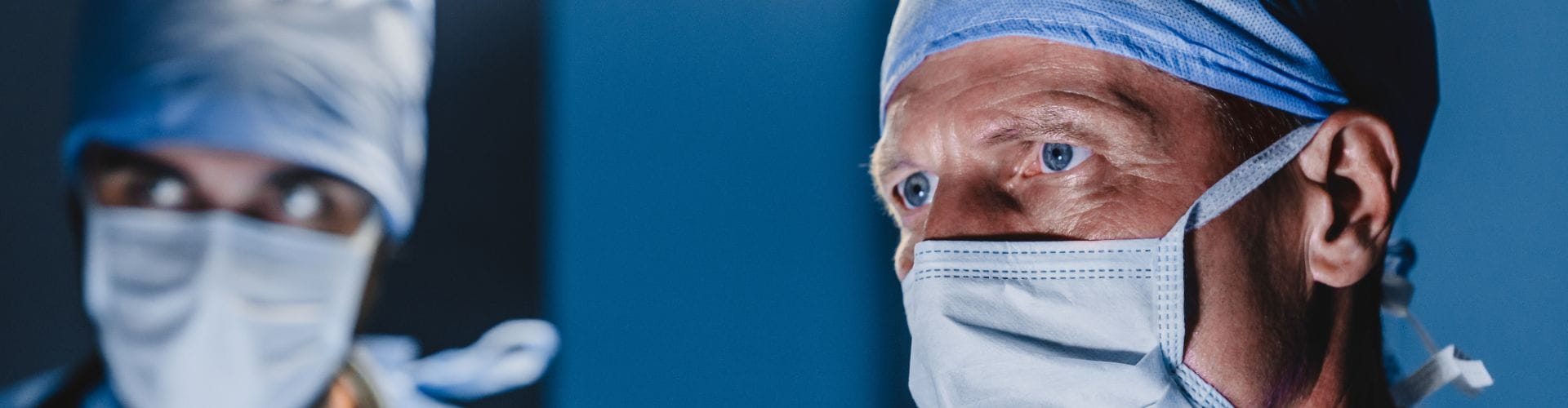 Un chirurgien et son assistant portent un masque