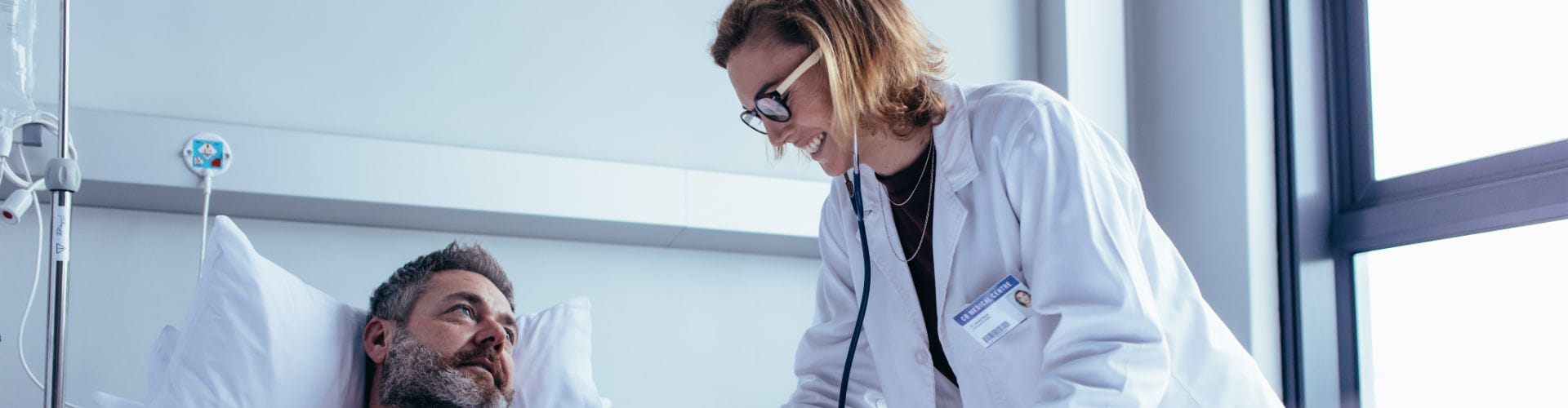 Une femme médecin examine un patient dans une chambre d'hôpital