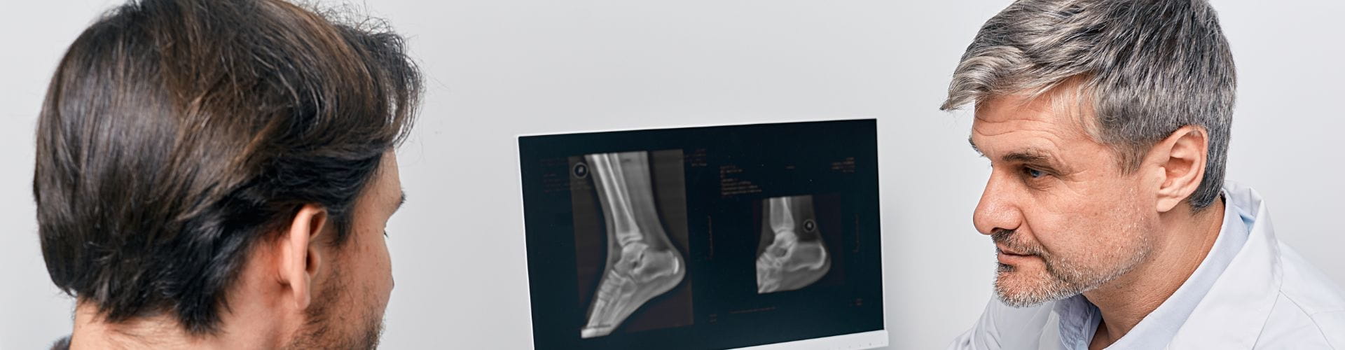 Un médecin explique une radio d’un pied à son patient