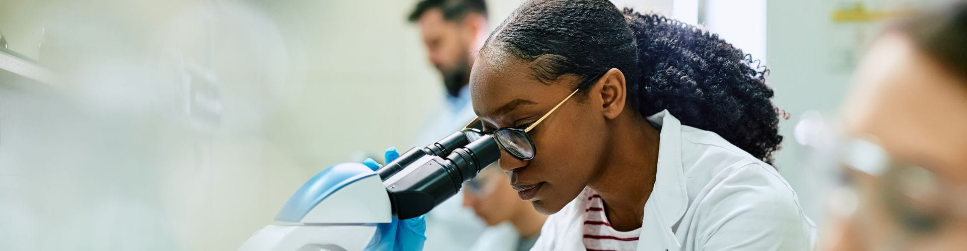 pharmacienne biologiste devant un microscope