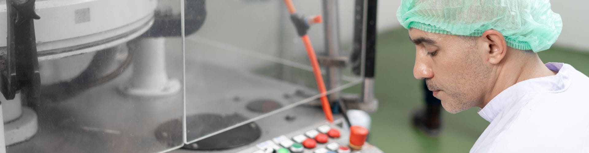 Un homme en tenue de protection examine une machine dans un laboratoire