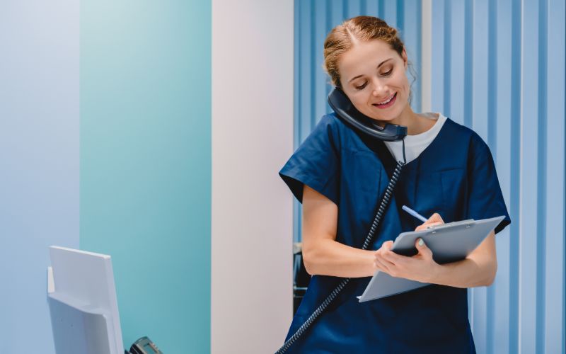 Une secrétaire médicale souriante au téléphone