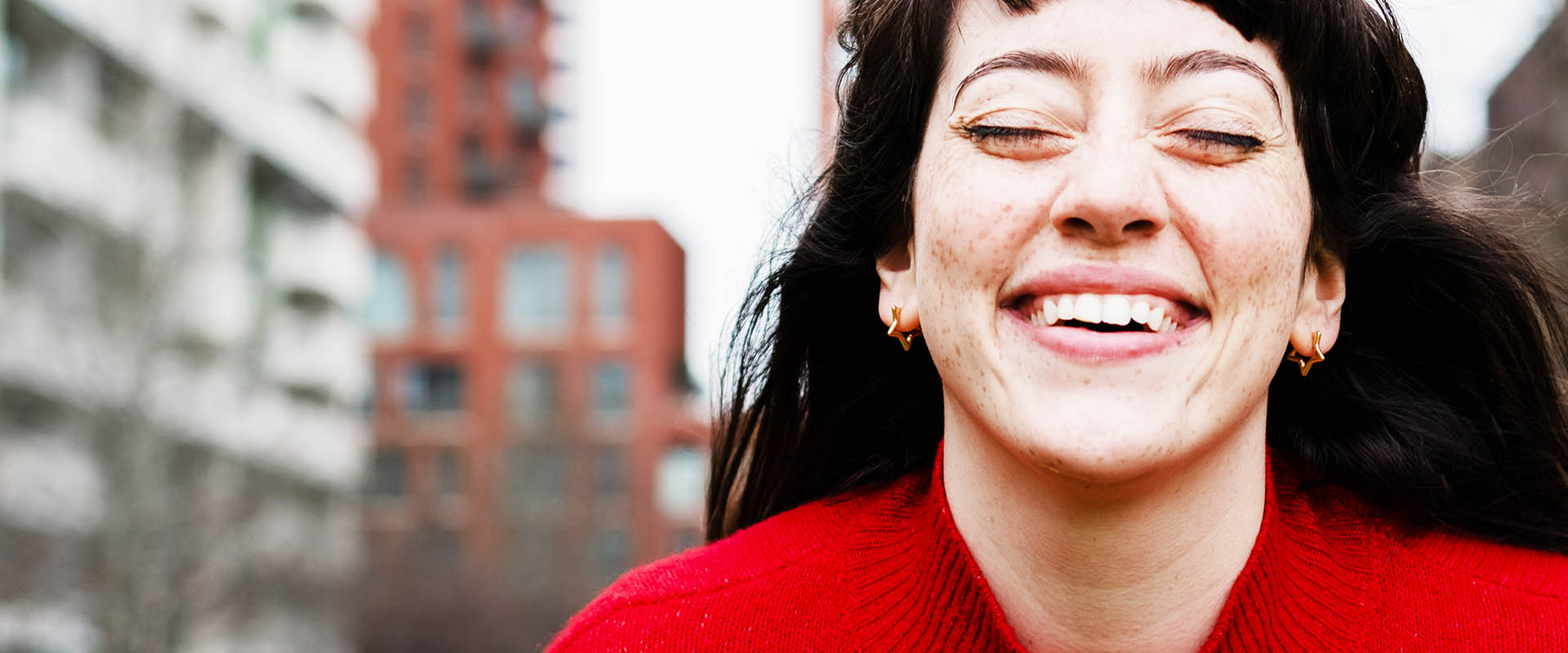 Person smiling outdoors in city street