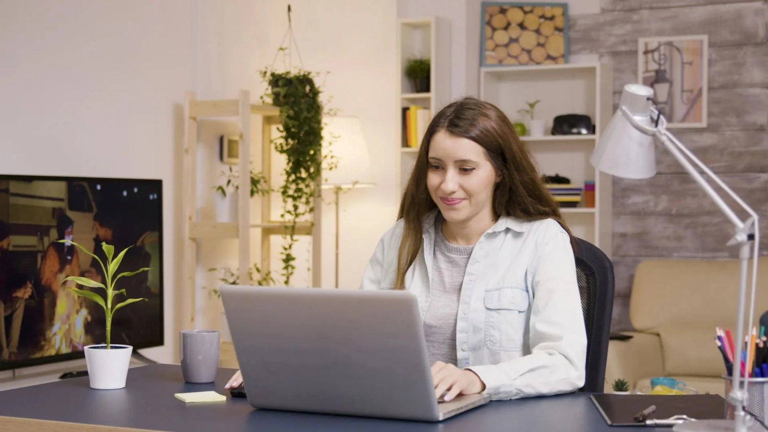girl-drinking-coffee-while-working-laptop-from-home-boyfriend-background