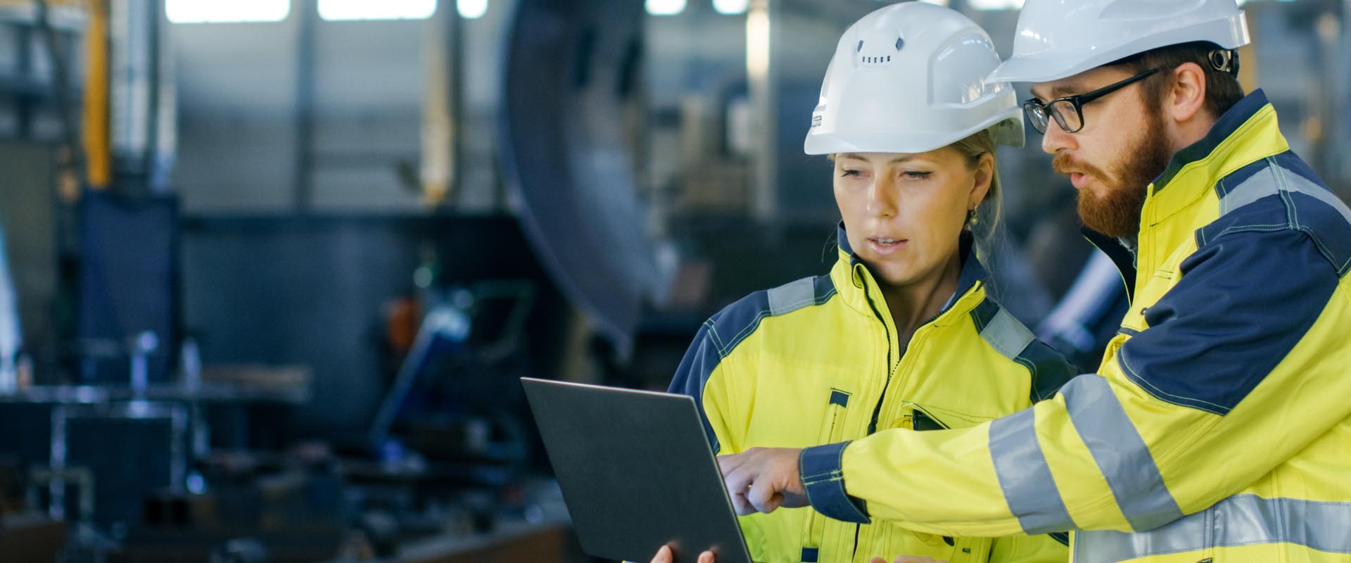 Engineers discussing a  project on-site with safety  gear