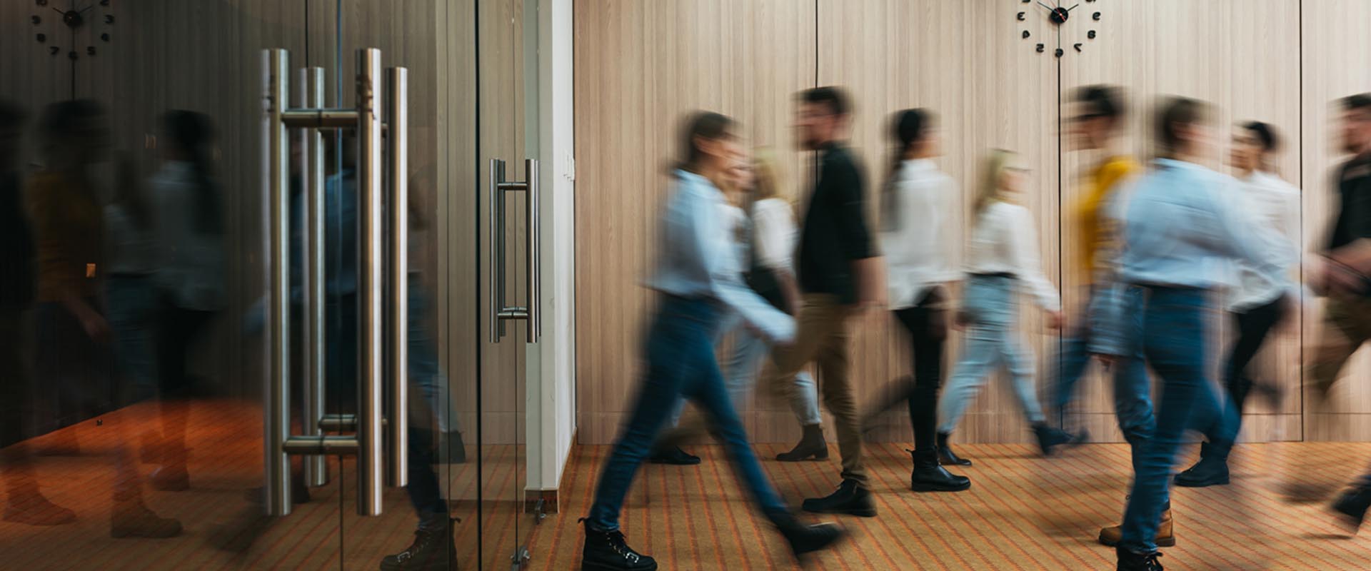 Blurred motion of people walking through a modern office lobby