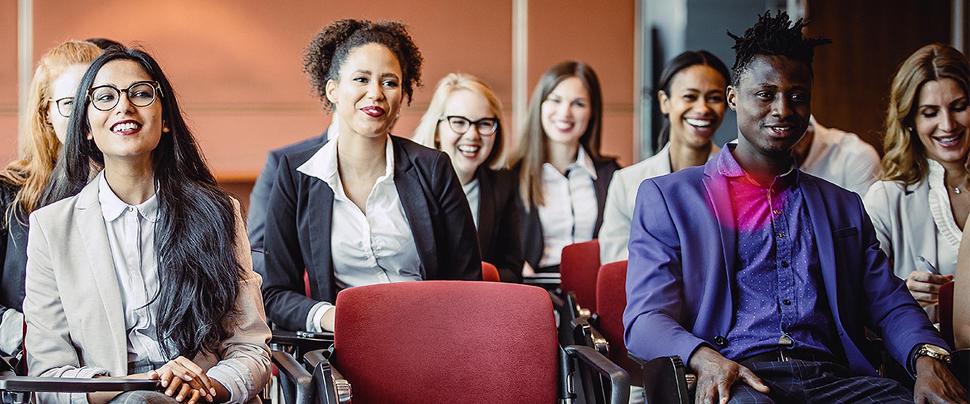 Business professionals seated at a presentation in a conference room