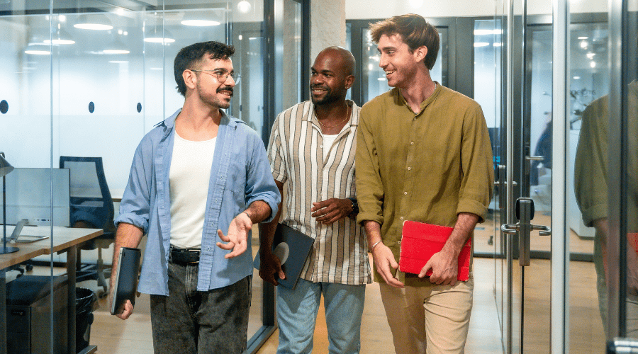 Three colleagues talking while walking through an office Three colleagues talking while walking through an office