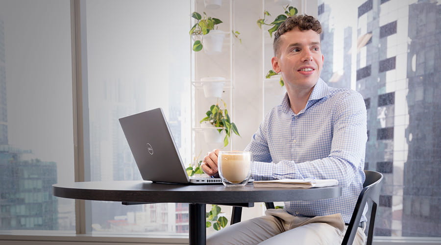 A man working on a laptop while looking to the side. A man working on a laptop while looking to the side.