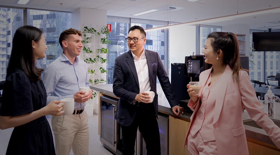 Four staff in discussion in a pantry. Four staff in discussion in a pantry.