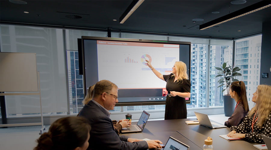 A woman presenting graphs in a meeting.