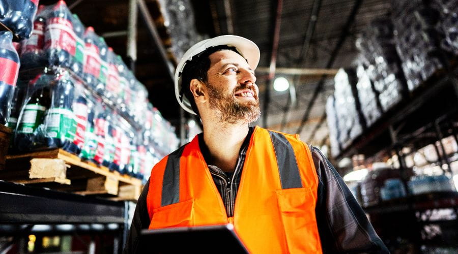 Worker in safety vest standing in industrial environment