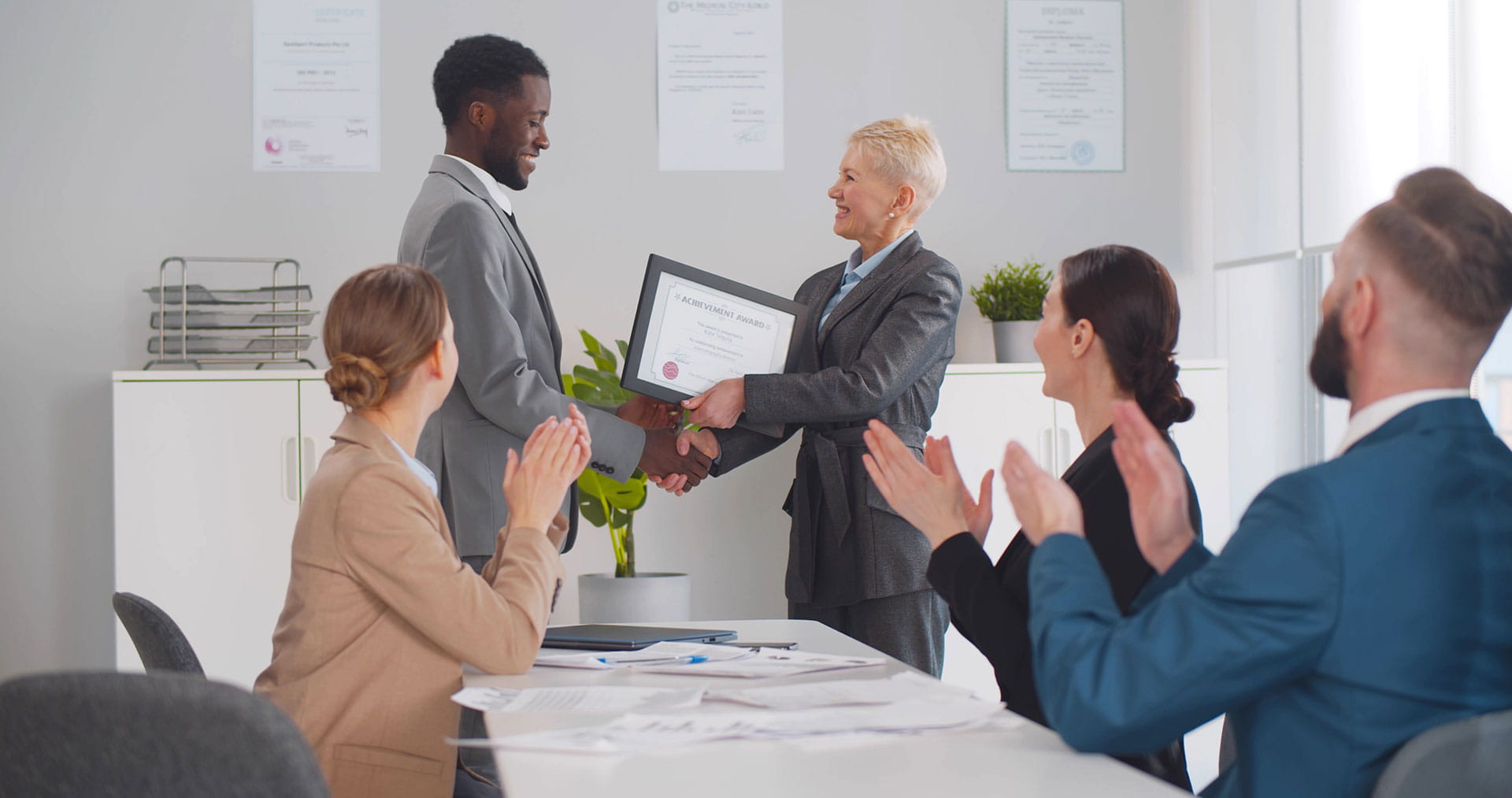 Le responsable montre son appréciation à l'employé lors d'une réunion d'équipe Le responsable montre son appréciation à l'employé lors d'une réunion d'équipe
