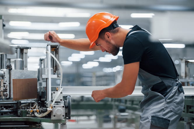 Produktionshelfer an einer Maschine