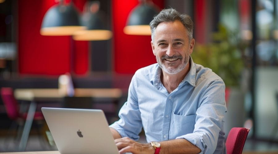 Lachende man achter laptop