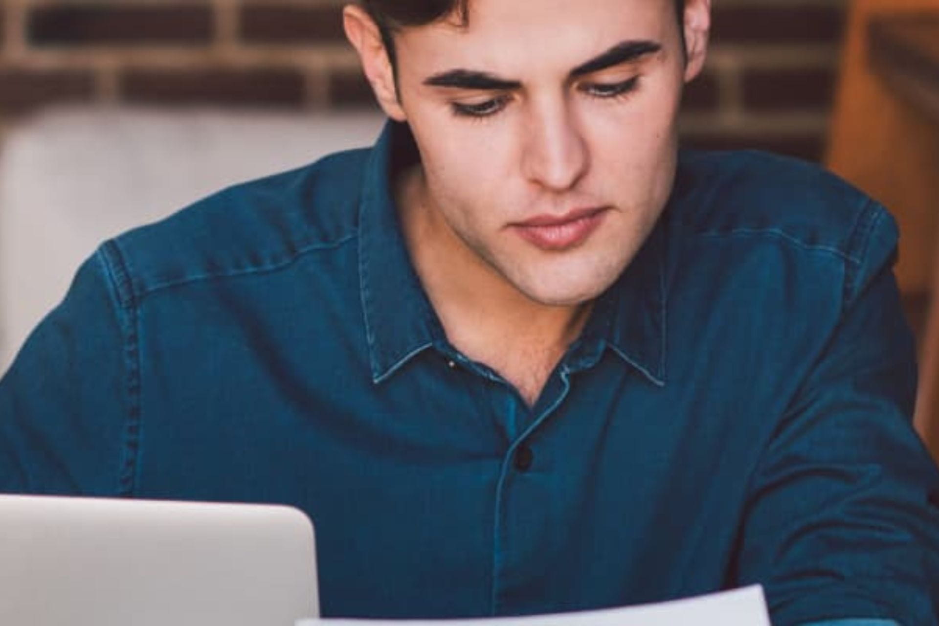Man werkt achter zijn laptop